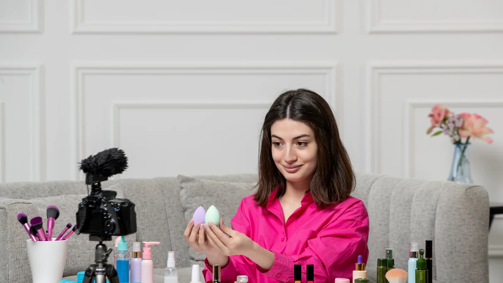 Nail artist filming a content video at home surrounded by beauty products