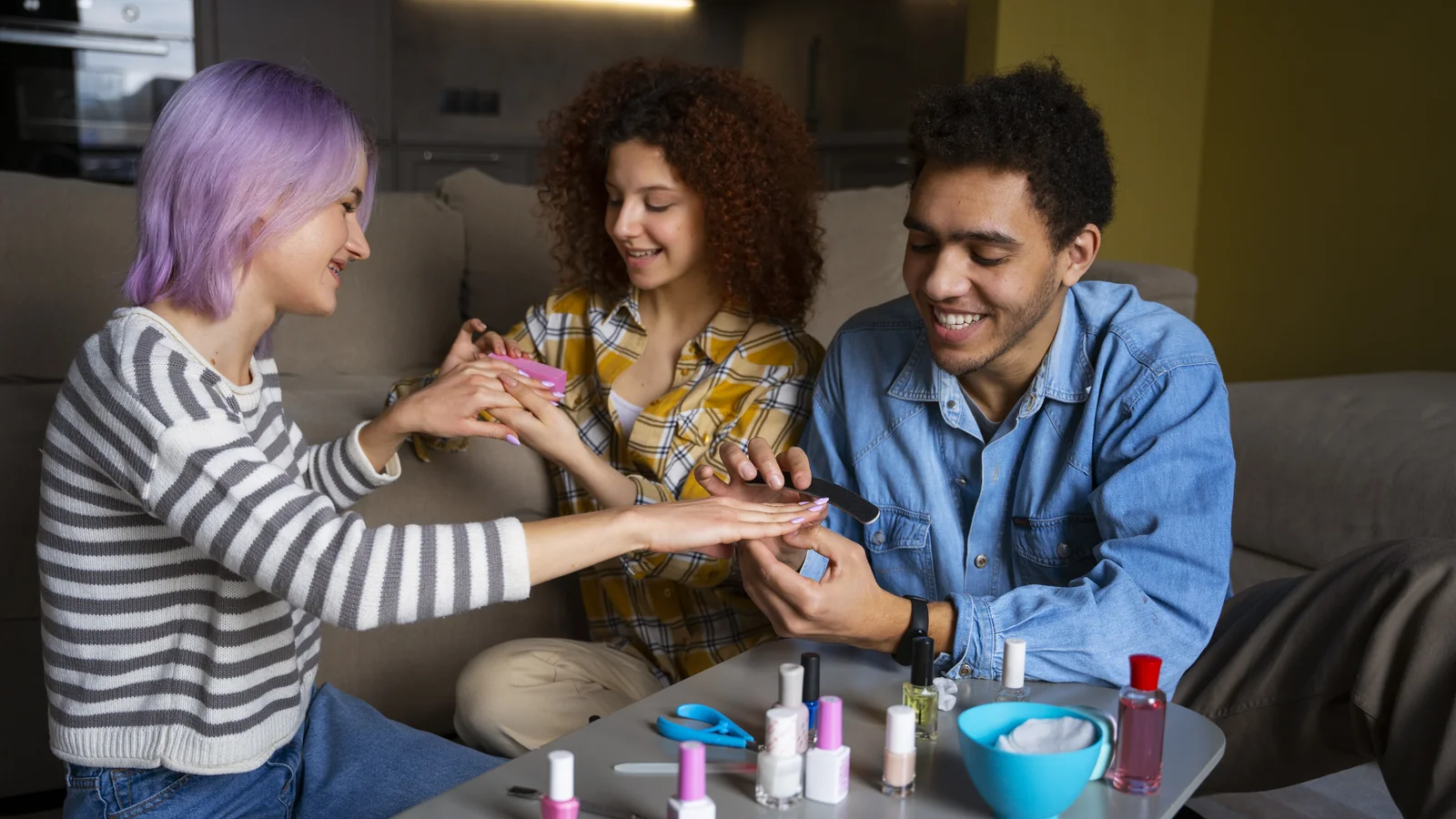 Three friends doing their nails together with polish bottles on the table
