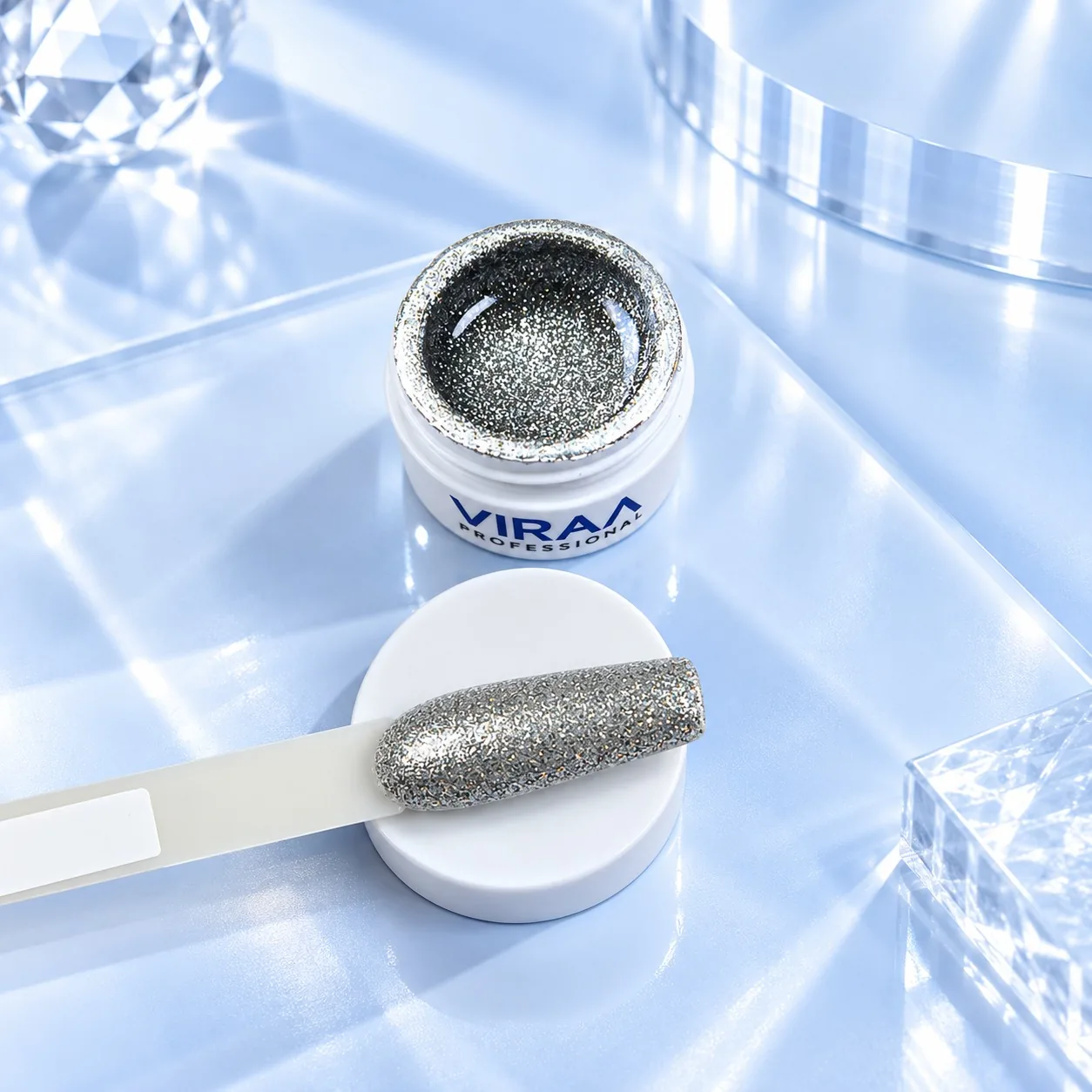Viraa Pro High Density Platinum Gel shade 010, a silver glitter, in its open 5gm pot with the shade painted on a sample tip