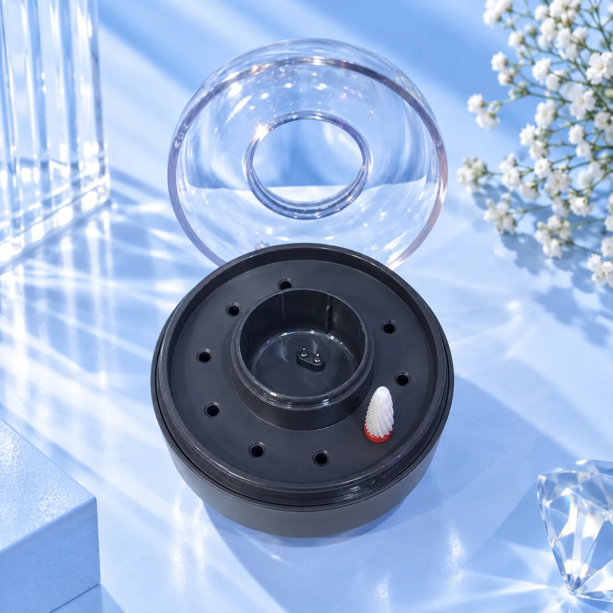 The black circular stand of the Viraa Pro rechargeable nail drill with its clear cover