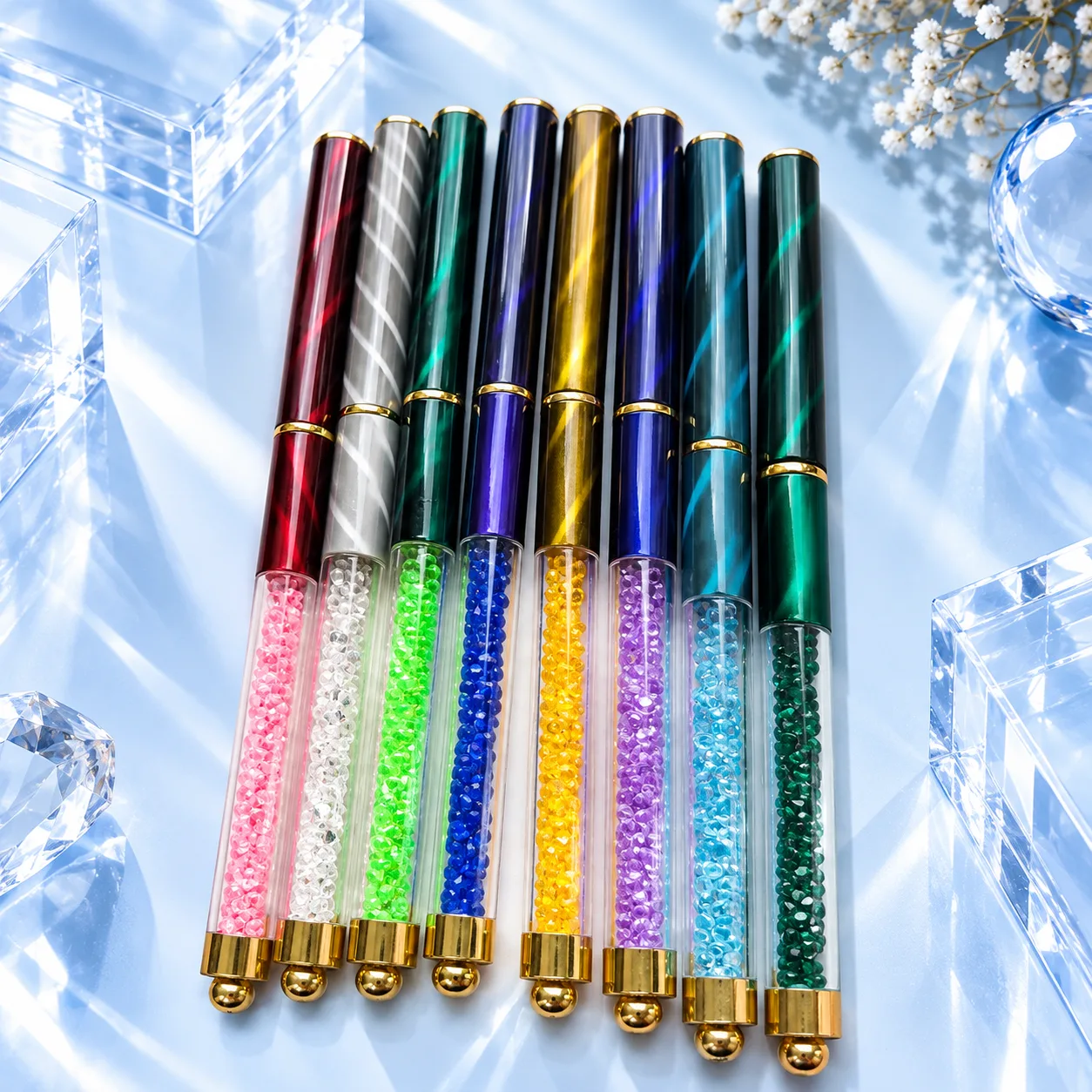 The eight capped brushes of the VIRAA Professional nail art brush set standing in a row, each with its own colour of crystal handle